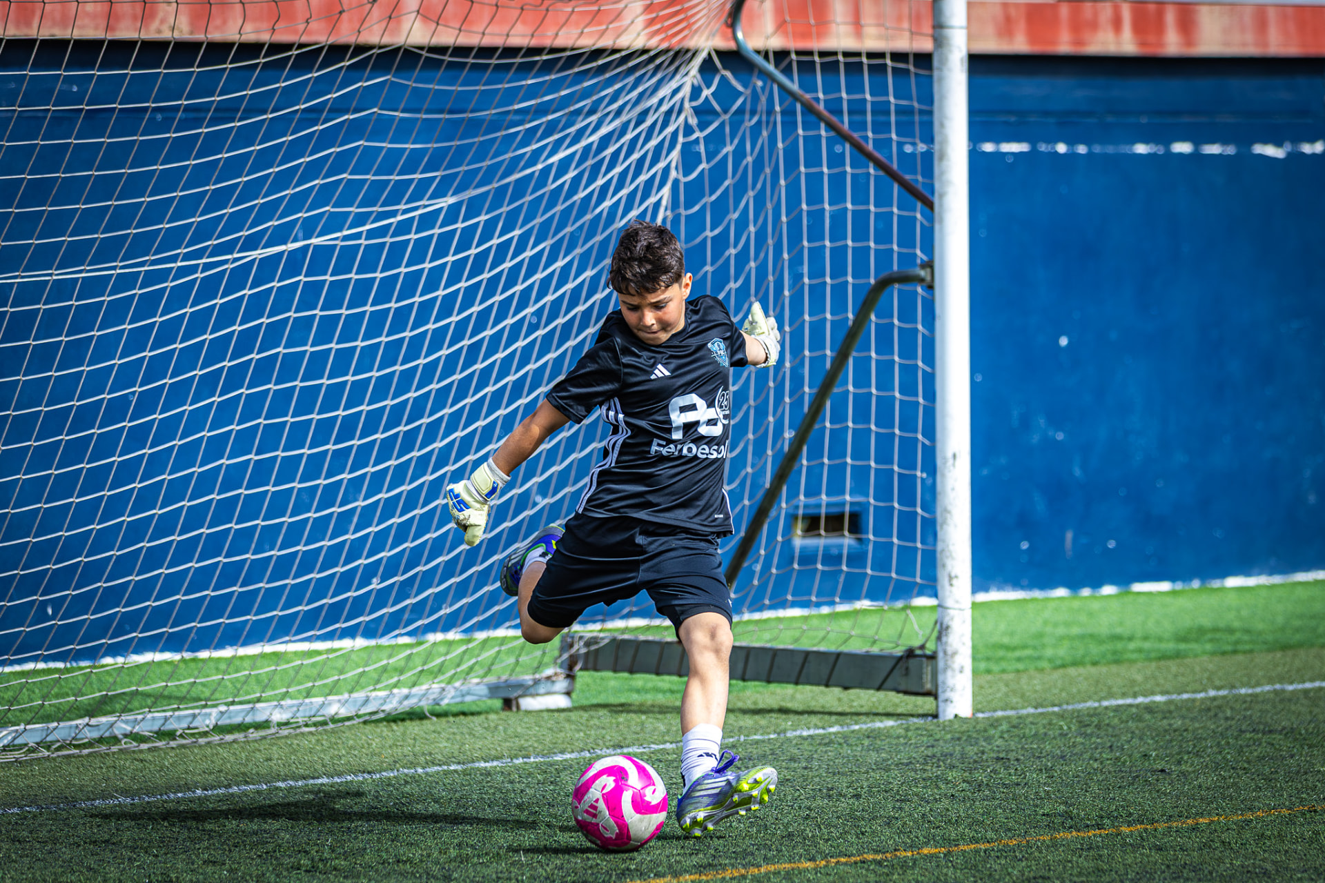 Portero pequeño golpeando el balón en el saque